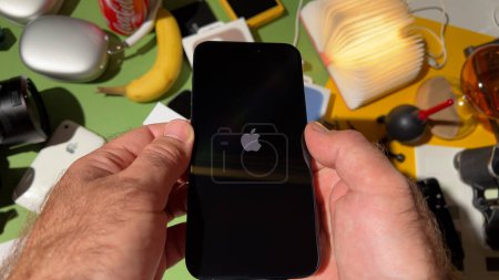 Téléchargez les photos : Londres, Royaume-Uni - 25 sept. 2023 : Insigne de logotype Apple sur l'écran du nouvel iPhone 15 Pro Max en titane dans une pièce conçue de manière créative lors de la première configuration initiale du déballage - en image libre de droit