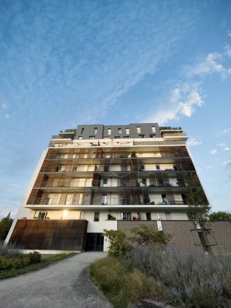Téléchargez les photos : Capturée sous un angle bas, cette large vue sur un immeuble moderne à Strasbourg, en France, met en valeur ses balcons rouges décoratifs, suggérant un investissement immobilier idéal. - en image libre de droit