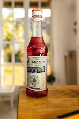 Foto de París, Francia - 12 de junio de 2023: Una mesa de cocina de madera exhibe una botella de aperitivo Monin, un producto de una firma francesa especializada en jarabes y licores principalmente para el sector de la hospitalidad - Imagen libre de derechos