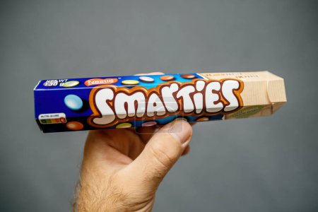 Photo for Paris, France - Jul 12, 2023: holds a package of Smarties, setting off the vividly colored candy against a muted gray background for an impactful visual contrast - Royalty Free Image