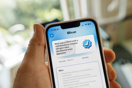 Foto de Hamburgo, Alemania - 24-jul-2023: Los suscriptores azules con un número verificado reciben una marca de verificación a través de la aplicación The X Twitter en un iPhone - Imagen libre de derechos