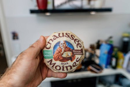 Foto de París, Francia - 4 de agosto de 2023: Una perspectiva de manos masculinas: Sostener un paquete de queso francés Chaussee aux Moines - Imagen libre de derechos