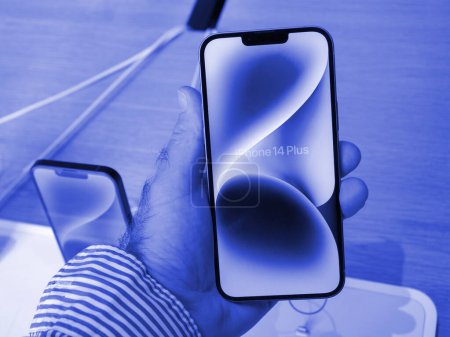 Foto de París, Francia - 22-sep-2023: mano masculina muestra el teléfono inteligente 14 Plus de vanguardia de la última línea de computadoras Apple, capturado en el marco de una Apple Store. - Imagen libre de derechos
