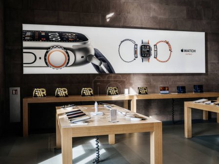 Photo for Paris, France - Sep 22, 2023: An empty Apple Store spotlights iPad tablets on display tables, while large-scale advertising highlights the new Watch Ultra 2 with updated components and display - Royalty Free Image