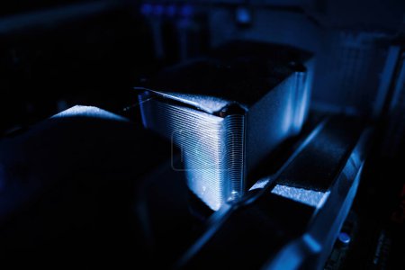 Photo for A blue color cast illuminates a close-up macro shot of a new, dusty powerful CPU computer cooler, with beam lighting accentuating the intricate radiator grille - Royalty Free Image