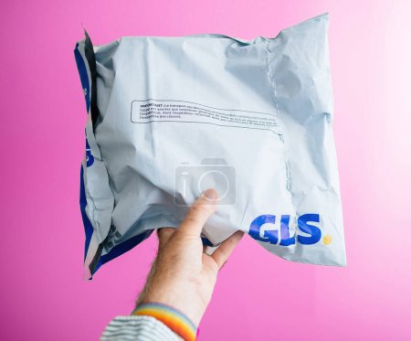 Photo for Paris, France - Sep 6, 2023: Male hand holds GLS white parcel with new brand logotype against pink background - symbolizing e-commerce delivery - Royalty Free Image