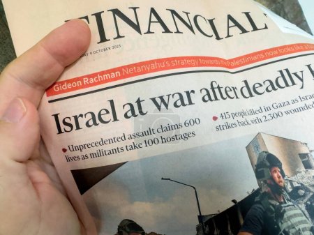Téléchargez les photos : Paris, France - 9 oct. 2023 : Une main masculine dans un tir POV fait la une : Israël en guerre après une agression sans précédent - Conflit Gaza-Israël dans le Financial Times - en image libre de droit