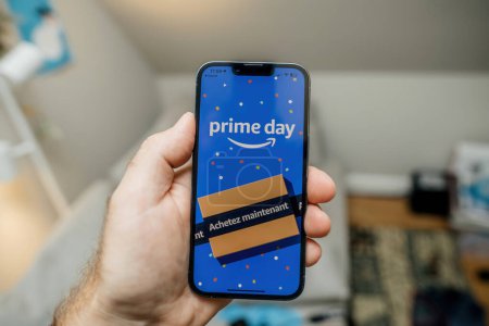 Photo for Paris, France - Jul 12, 2023: male hand skillfully holds an Apple iPhone displaying a Buy Now banner in French as part of a Prime Day promotion, capturing the essence of time-sensitive online shopping - Royalty Free Image