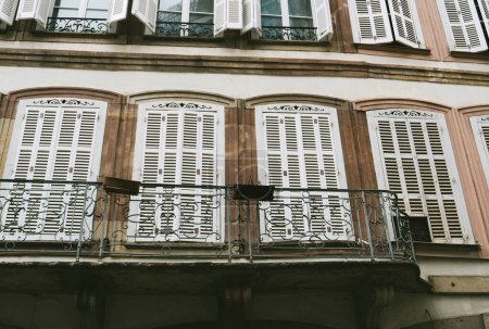 Photo for Low-angle view of multiple French balconies with closed blinds, conveying a real estate property concept. - Royalty Free Image