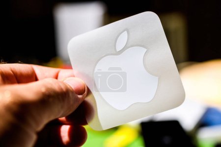 Photo for London, UK - Sep 28, 2023: Unboxing the latest iPhone 15 Pro, a male hand holds the iconic white Apple Computers logo sticker - with a defocused background - Royalty Free Image