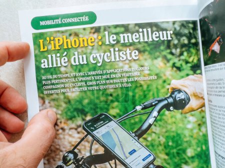 Foto de París, Francia - 11 de octubre de 2023: iPhone: El mejor aliado de un ciclista - Titular de un periódico con el último iPhone 15 Pro de Apple Computers - Imagen libre de derechos