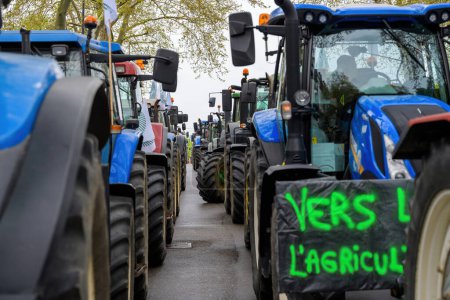 Téléchargez les photos : Strasbourg, France - 30 avril 2021 : Des centaines de tracteurs agricoles alignés à Strasbourg, dont un arborant un panneau traduit par "À l'agriculture lors d'une manifestation" - en image libre de droit