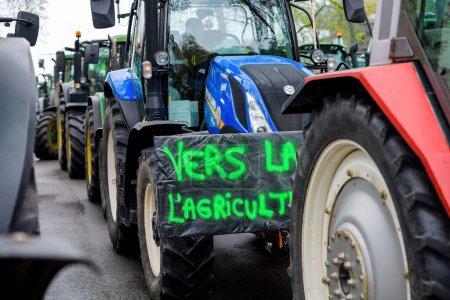 Photo for Strasbourg, France - April 30, 2021: Hundreds of agriculture tractors lined up, with signage on one translated as To the Agriculture, during a protest in Strasbourg - Royalty Free Image