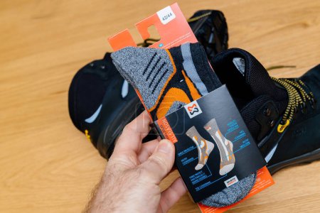 Photo for Hamburg, Germany - Feb 16, 2022: Male hand expertly modifying all-season Wurth socks with multiple enhancements: ankle protectors, heel cushioning, and more - Royalty Free Image