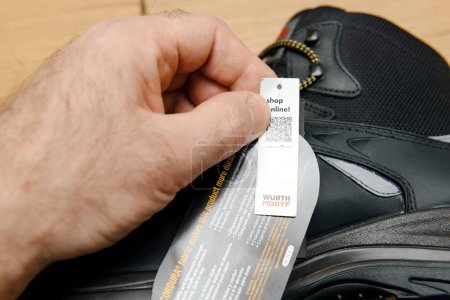 Photo for Hamburg, Germany - Feb 16, 2022: Examining the specifications label on Wurth Modyf working shoes with meticulous attention - Royalty Free Image