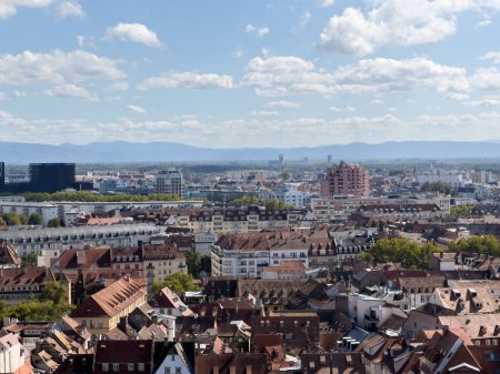 Téléchargez les photos : Strasbourg Centre : Des maisons alsaciennes à colombages et de grands bâtiments encadrent la vue sur les Vosges au loin - vue aérienne - en image libre de droit