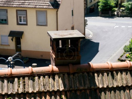 Téléchargez les photos : D'un point de vue aérien, le toit pittoresque d'une maison de village française est orné d'une cheminée. - en image libre de droit