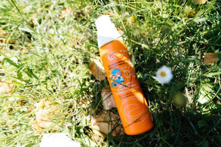 Photo for Paris, France - Jun 3, 2023: a prominently placed orange-colored bottle of sunscreen mask, crafted by Avene with SPF 50 for children, stands as a protective sentinel in the verdant embrace of the - Royalty Free Image