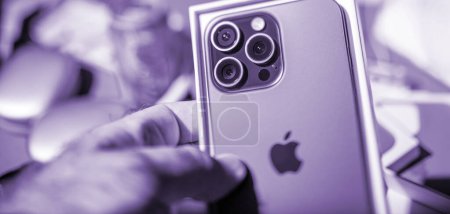Foto de Londres, Reino Unido - 28-sep-2023: mano presenta el nuevo Apple Computers iPhone 15 Pro con una cámara triple y zoom 5x durante un unboxing oficial - Imagen libre de derechos