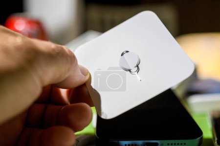 Téléchargez les photos : Londres, Royaume-Uni - 28 sept. 2023 : Apple Computers outil d'éjection en acier pour ouvrir le compartiment SIM afin d'insérer une nouvelle carte pour la voix et les données lors du déballage iPhone 15 Pro - en image libre de droit