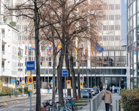 Foto de Estrasburgo, Francia - 22 de noviembre de 2023: Un cartel de taxi se muestra prominentemente a lo largo de una calle, con el edificio Winston Churchill del Parlamento Europeo en el fondo. - Imagen libre de derechos