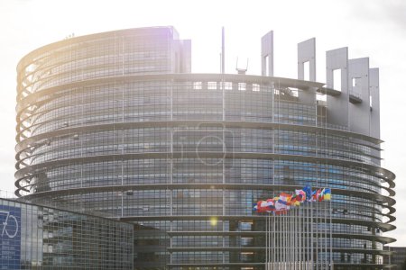 Foto de La moderna fachada del edificio del Parlamento Europeo en Estrasburgo, con paneles de vidrio y una serie de banderas que representan a los Estados miembros de la UE - Imagen libre de derechos