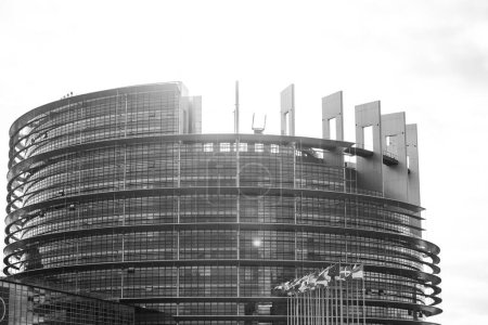 Photo for A black and white capture of the European Parliament building in Strasbourg, emphasizing its modern architectural lines, with silhouetted national flags in the foreground. - Royalty Free Image