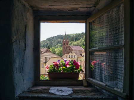 Foto de Desde un punto de vista único dentro de una vivienda troglodita, una ventana abierta ofrece un marco cautivador, destacando el distante Eglise protestante Grauftha - Imagen libre de derechos