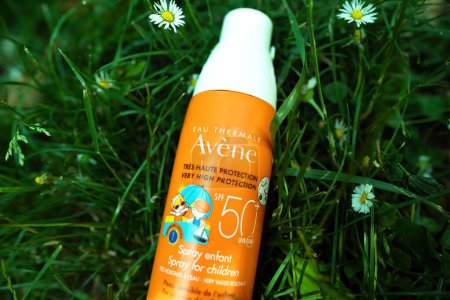 Photo for Paris, France - Jun 6, 2023: A bottle of Eau Thermale Avene sun spray, specifically designed for children, stands amidst vibrant green grass. - Royalty Free Image