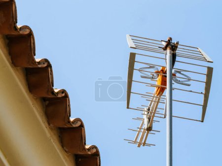 Foto de Una vista de bajo ángulo de una antena aérea montada en un poste, transmitiendo diligentemente una multitud de señales de radio y televisión en formato digital - Imagen libre de derechos