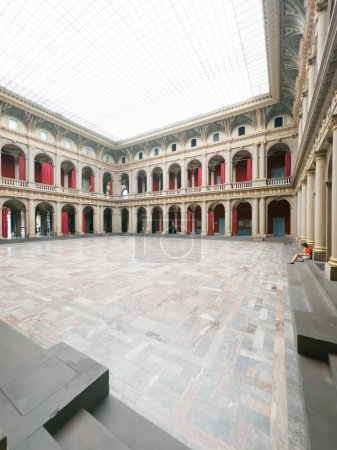 Photo for Inside the Palais Universitaire de Strasbourg, the largest university in Alsace, a spacious atrium accommodates a lone student, surrounded by golden-plaqued columns and historic architectural grandeur - Royalty Free Image