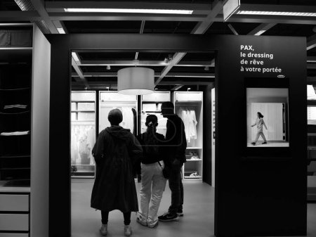 Téléchargez les photos : Paris, France - 31 août 2023 : Une photographie en noir et blanc représente des consommateurs à l'intérieur du magasin suédois IKEA, désireux de choisir un meuble d'armoire de toilette PAX pour leur maison - en image libre de droit