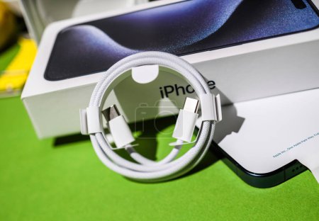 Téléchargez les photos : Londres, Royaume-Uni - 28 sept. 2023 : déballage de l'Apple Computers iPhone 15 Pro Max, un câble de charge tressé USB-C prend le devant de la scène en tant qu'objet héros - en image libre de droit