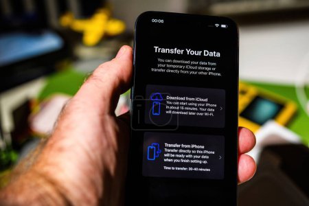 Photo for London, UK - Sep 28, 2023: A male user sets up the latest iPhone 15 Pro Max, exploring data transfer options. The process includes downloading from iCloud or transferring data from another iPhone - Royalty Free Image