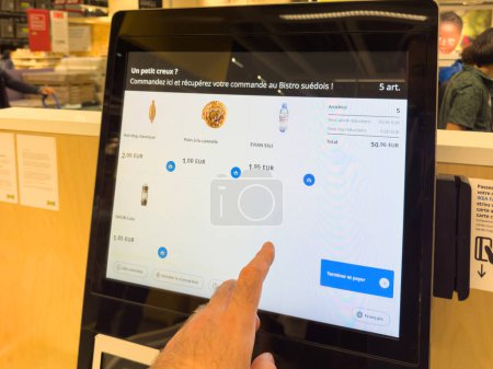 Foto de París, Francia - 4 de octubre de 2023: Una vista detallada de una pantalla táctil del quiosco de autoservicio IKEA que muestra los alimentos, sus descripciones y precios en EUR, listos para la compra. - Imagen libre de derechos