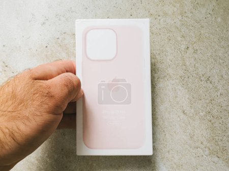 Foto de París, Francia - 10 de octubre de 2023: Acercamiento de una mano que sostiene un paquete de caja de silicona iPhone 13 Pro con un color rosa claro - Imagen libre de derechos
