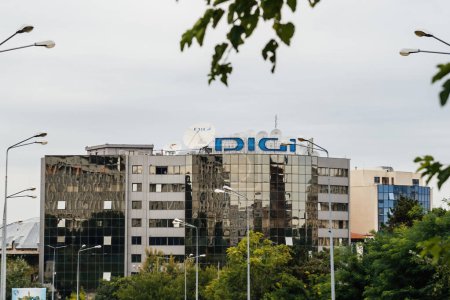 Téléchargez les photos : Bucarest, Roumanie - 1 oct. 2015 : Le bâtiment du siège de DIGI, un opérateur roumain de câble et d'Internet, se dresse dans un décor urbain, sa façade miroir reflétant l'environnement urbain - en image libre de droit