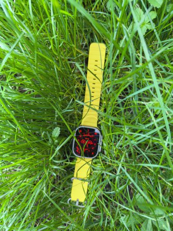 Photo for London, United Kingdom - Sep 23, 2022: new titanium Apple Watch Ultra is showcased in green grass, its Night Mode activated for optimal viewing in low-light conditions, emphasizing its adaptability - Royalty Free Image