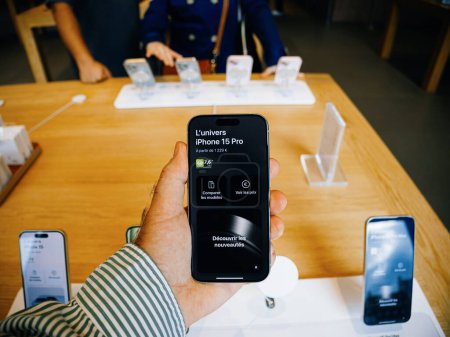 Téléchargez les photos : Paris, France - 22 sept. 2023 : Le jour du lancement, une main d'homme tient un iPhone 15 affichant le texte Univers de l'iPhone 15 pro dans un Apple Store - en image libre de droit