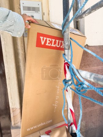 Foto de París, Francia - 27-sep-2023: Una mano de obra recupera residuos de cartón con el logotipo de Velux windows cerca de la entrada de un edificio durante la renovación y construcción - Imagen libre de derechos
