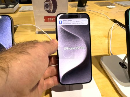 Photo for Strasbourg, France - Oct 1, 2023: A customers male hand holds the iPhone 15 Pro, admiring its new titanium construction and the advanced improvements in its CPU and GPU performance - Royalty Free Image