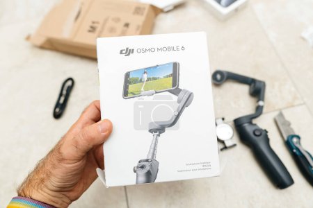Photo for Paris, France - Oct 24, 2023: A male hand is captured in the process of unboxing an Osmo Mobile 6 gimbal, complete with ActiveTrack 5.0 and more, from an Amazon Prime delivered parcel - Royalty Free Image