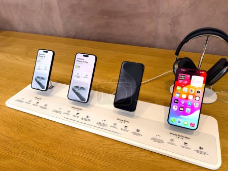 Foto de París, Francia - 22-sep-2023: Se muestra toda la gama de modelos Apple iPhone 15, Plus y Pro, con los auriculares inalámbricos AirPods Max destacados en segundo plano - Imagen libre de derechos