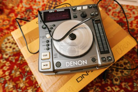 Téléchargez les photos : Paris, France - 30 oct. 2023 : Une manette de table de mixage Denon Professional DN-S1000 DJ est exposée sur un tapis de soie luxueux dans un cadre de salon - en image libre de droit