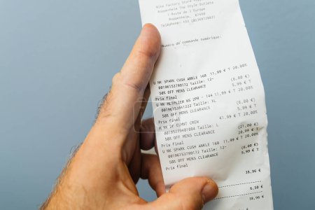 Photo for Paris, France - Oct 30, 2023: a male hand holding a receipt detailing several sports items bought at a Nike outlet in Roppenheim, all at 50 percent off - Royalty Free Image