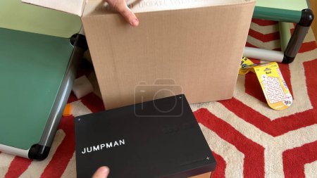 Photo for Paris, France - Sep 2023: A male hand is captured holding a packaged cardboard box containing Jumpman shoes by Jordan, symbolizing the acquisition of sought-after athletic footwear - Royalty Free Image