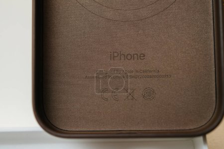 Téléchargez les photos : Paris, France - 25 oct. 2023 : Conçu par Apple en Californie, le texte assemblé en Chine figure sur une nouvelle coque de remplacement en cuir finement tissé pour iPhone, mettant en valeur l'artisanat - en image libre de droit