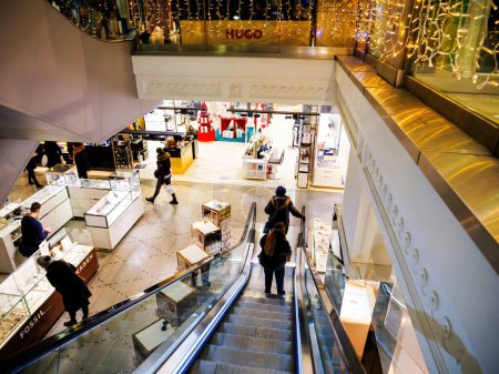 Foto de Estrasburgo, Francia - 12 de diciembre de 2022: Vista desde la escalera mecánica que captura la ajetreada escena de las compras dentro de las galerías Lafayette decoradas con Navidad, un lugar icónico en Francia - Imagen libre de derechos