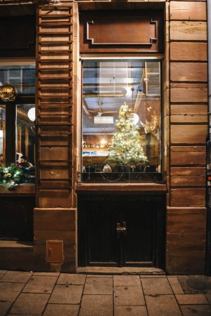 Foto de Estrasburgo, Francia - 19-dic-2022: Un acogedor restaurante interior adornado con decoraciones navideñas ofrece un cálido refugio para los comensales que disfrutan de su comida en un entorno festivo - Imagen libre de derechos