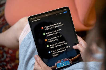 Foto de Londres, Reino Unido - 13 de septiembre de 2023: Una mujer se dedica a leer detalles sobre el Apple Watch Series 9, el reloj inteligente más reciente de Apple, en su tableta iPad Pro - Imagen libre de derechos